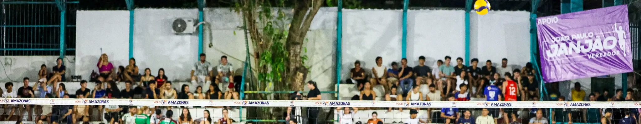 Público assistindo a uma partida de vôlei em ginásio