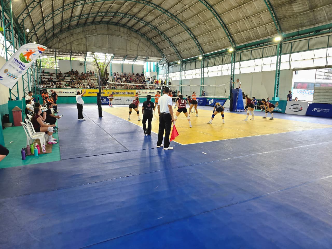 Partida feminina da A.A. Nilton Lins com arbitragem e público nas arquibancadas